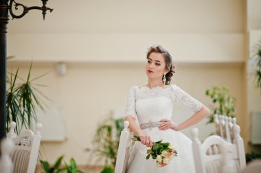 Sandalyeler ve tabl yakın düğün salonunda güzel gelin portresi