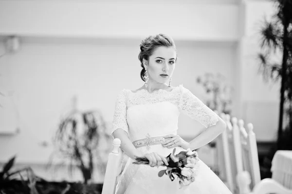 Portret van de mooie bruid op Bruiloftszaal in de buurt van stoelen en tabl — Stockfoto