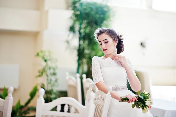 Retrato de noiva bonita no salão de casamento perto de cadeiras e tabl — Fotografia de Stock