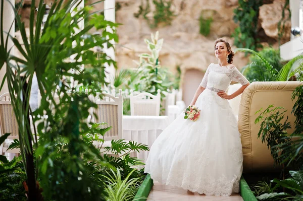 美丽的新娘在婚礼大厅植物在背景中的肖像 — 图库照片
