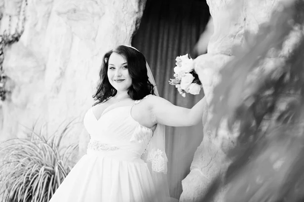 Брюнетка с большой грудью, невеста со свадебным букетом на свадьбе — стоковое фото