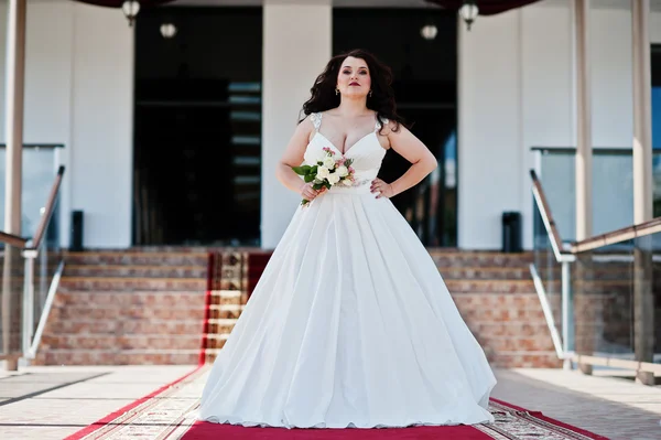 Grote borsten brunette bruid met bruiloft boeket gesteld op bruiloft — Stockfoto