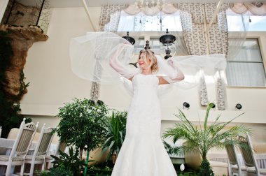 Muhteşem sarışın gelin uzun örtü ile harika muhteşem düğünü poz verdi.