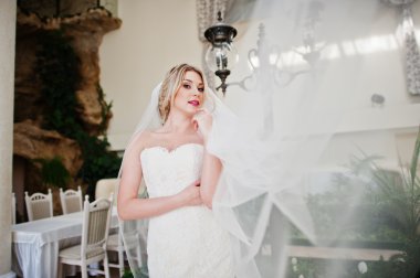 Muhteşem sarışın gelin uzun örtü ile harika muhteşem düğünü poz verdi.