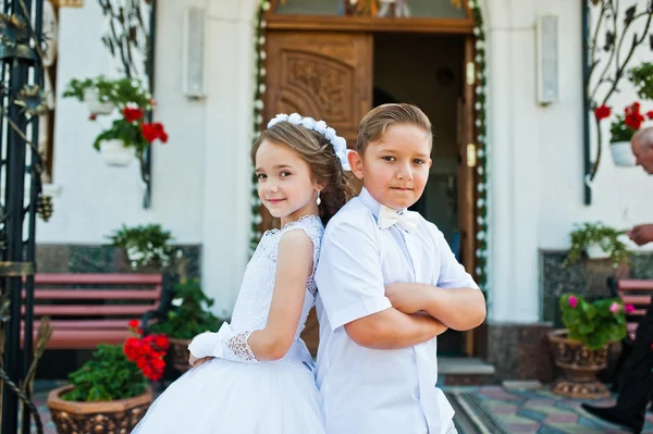 Primera comunión santa, hermano y hermana se quedan en el bac vestido blanco — Foto de Stock