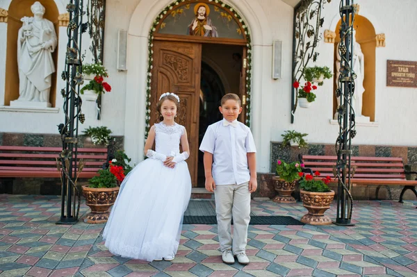 Πρώτη θεία κοινωνία, τον αδελφό και αδελφή μείνετε στο λευκό φόρεμα bac — Φωτογραφία Αρχείου