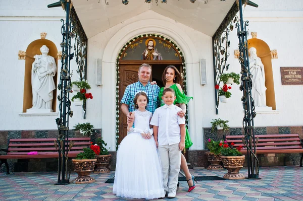 Família feliz na primeira comunhão santa ficar fundo igreja — Fotografia de Stock