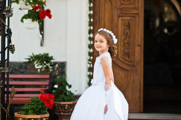 Ritratto di bambina carina su abito bianco e ghirlanda sul primo — Foto Stock