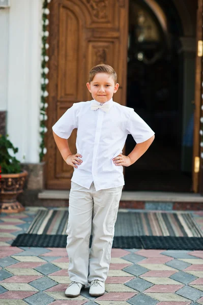 Porträt eines kleinen Jungen auf weißem Kleid und Fliege am ersten heiligen c — Stockfoto