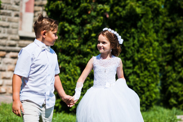 Portrait of brother and sister on white dress at sunny day