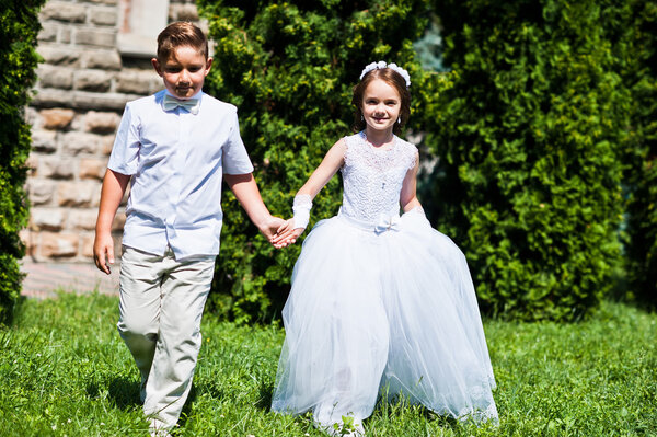 Portrait of brother and sister on white dress at sunny day