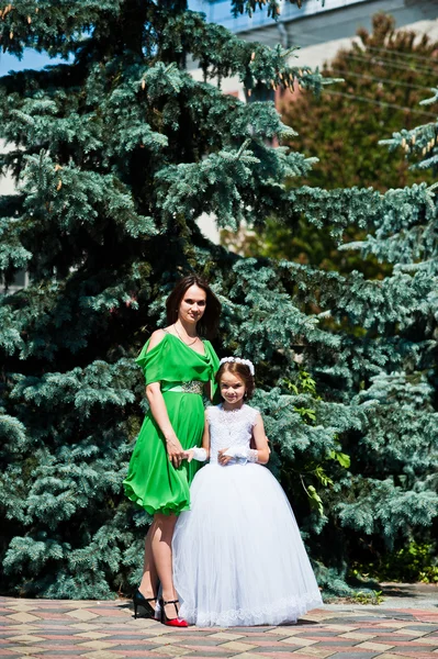 Moeder en dochter op witte en groene jurk op zonnige dag — Stockfoto