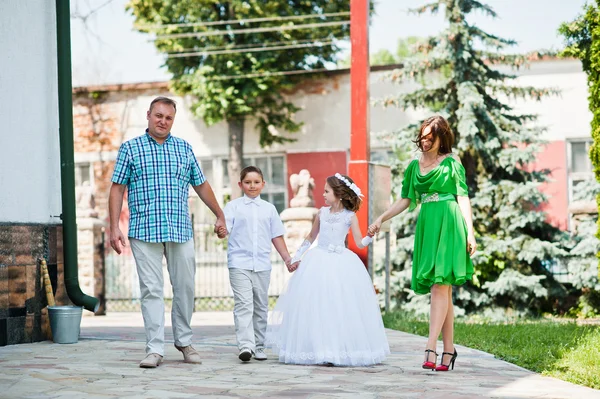 Glückliche Familie bei der ersten heiligen Kommunion zu Fuß Hintergrund Kirche c — Stockfoto