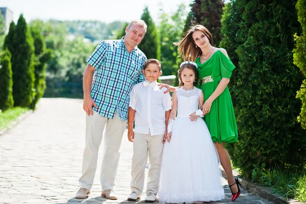 Šťastný rodinný pobyt v uličce thuja a při pohledu na fotoaparát — Stock fotografie