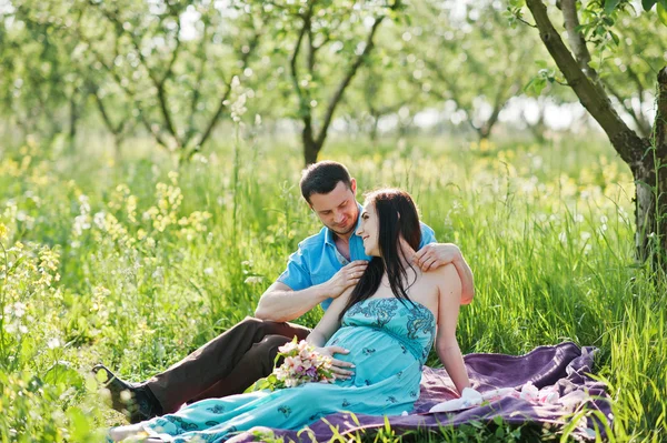 Szczęśliwa para w ciąży o turkusowa sukienka na ogród — Zdjęcie stockowe