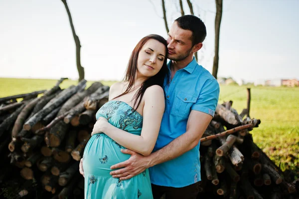 Feliz casal grávida no vestido turquesa no jardim — Fotografia de Stock