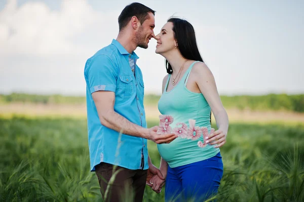 Feliz casal grávida no campo de grinalda no amor — Fotografia de Stock