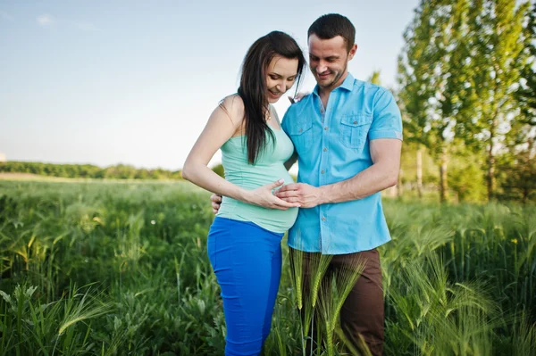 Happy pregnant couple on wreath field in love — Stock Photo, Image