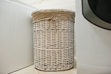 White wicker basket for dirty clothes at bathroom clipart