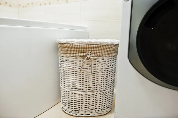 Белая плетеная корзина для грязной одежды в ванной комнате — стоковое фото