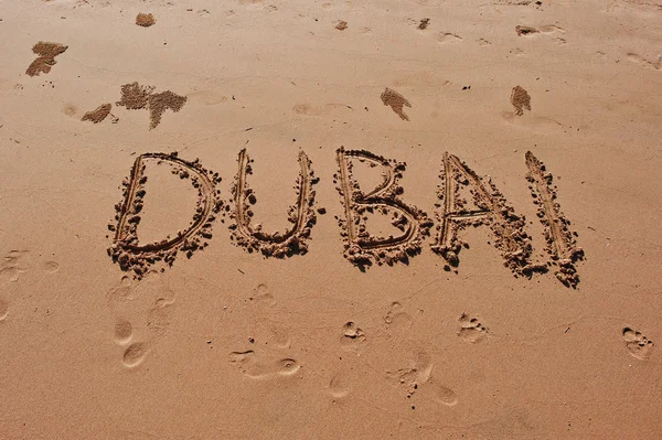 "Dubaj "napisane w piasku na plaży — Zdjęcie stockowe