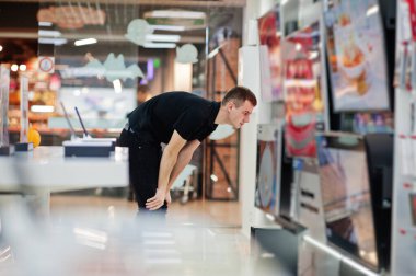 Satıcı adam teknoloji mağazasında ya da akıllı televizyonun yanındaki tezgâhta profesyonel danışman..