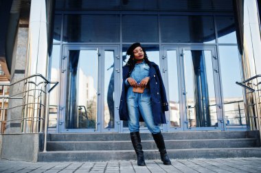 Şık, modaya uygun, kot pantolon giyen Afro-Amerikan kadınları ve modern binaya karşı mavi ceketli siyah bereli kadınlar..