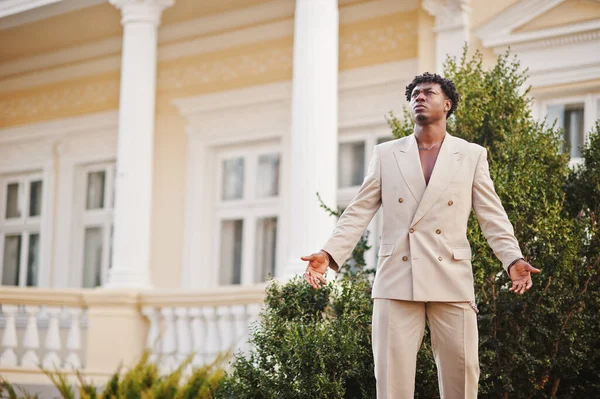 Stylish afro man in beige old school suit. Fashionable young African male in casual jacket on bare torso.