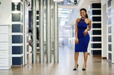 Lokantada poz veren mavi elbiseli Afro-Amerikan kadın..