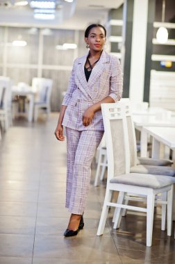 Çekici Afrikalı Amerikalı kadın ceketli, restoranda poz veriyor..