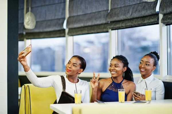 Três Africanas Vestido Posando Restaurante Bebendo Suco Fazendo Selfie Telefone — Fotografia de Stock