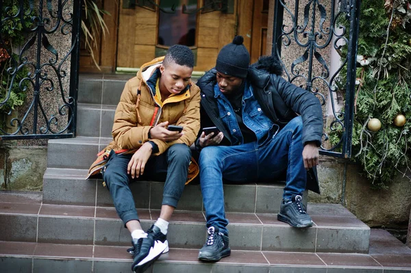 Dos Amigos Africanos Sentados Mirando Juntos Por Teléfono — Foto de Stock