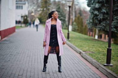 Genç, şık, güzel, Afro-Amerikalı bir kadın. Moda kıyafeti giymiş..