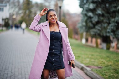 Genç, şık, güzel, Afro-Amerikalı bir kadın. Moda kıyafeti giymiş..