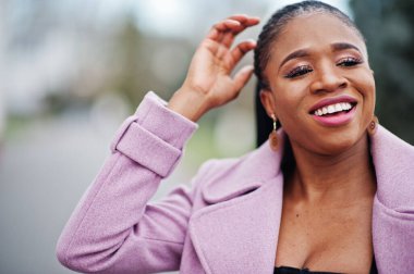 Genç, şık, güzel, Afro-Amerikalı bir kadın. Moda kıyafeti giymiş..