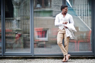 Düşünceli, genç, yakışıklı, Afro-Amerikalı, resmi giysili bir beyefendi. Beyaz ceketli, siyah şık bir adam..