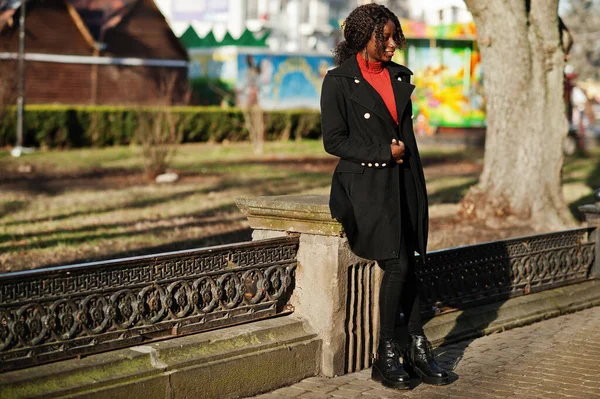 Портрет Кудрявой Африканки Модном Черном Пальто Красной Водолазке Позирующей Открытом — стоковое фото