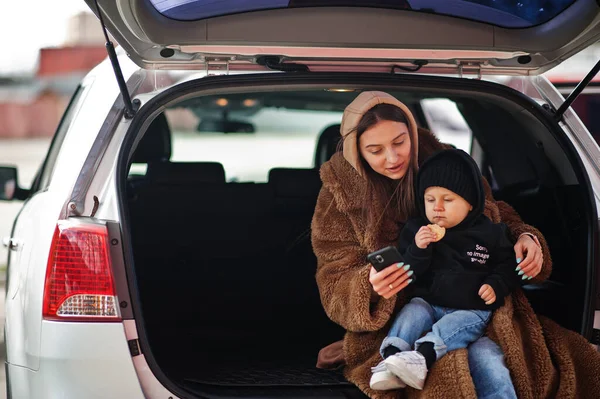 Молода Мама Дитина Сидять Багажнику Автомобіля Дивляться Мобільний Телефон Концепція — стокове фото