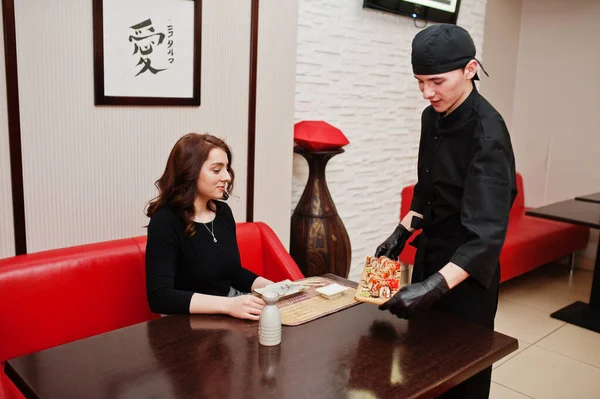 Profesjonalny Kucharz Czerni Daje Sushi Rolki Dla Klientki Restauracji Japońskiej — Zdjęcie stockowe