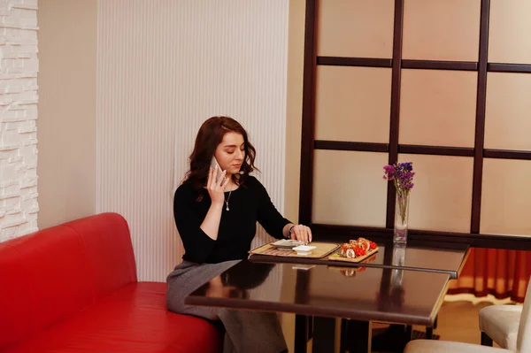 Una Joven Hermosa Chica Habla Por Teléfono Mientras Come Sushi —  Fotos de Stock