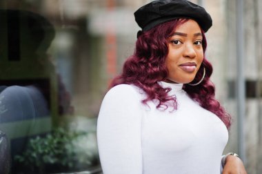 Büyük anne artı Afrikalı Amerikan modeli siyah bereli ve deri etekli açık havada poz verdi..