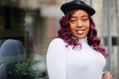 Büyük anne artı Afrikalı Amerikan modeli siyah bereli ve deri etekli açık havada poz verdi..