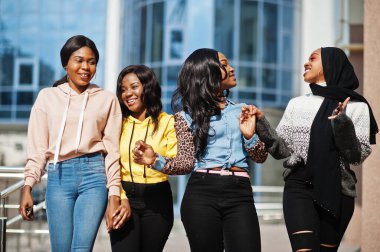 Four young college african american woman friends spend time together. clipart