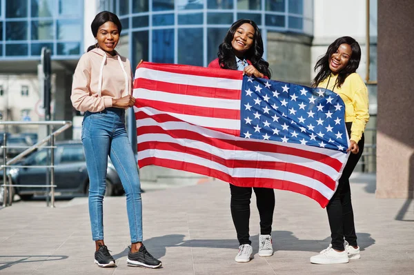 Three young college african american womans friends with flag of USA.