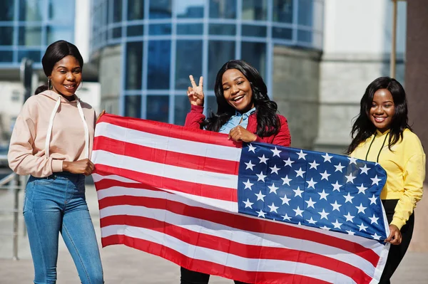 Three young college african american womans friends with flag of USA.