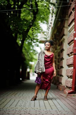 Afro saçlı, güzel, doğal bir Afrikalı kadının portresi. Kırmızı ipek elbiseli siyah model..