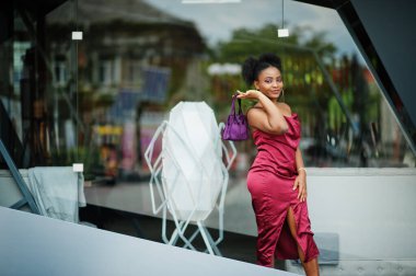 Afro saçlı, güzel, doğal bir Afrikalı kadının portresi. Kırmızı ipek elbiseli siyah model..