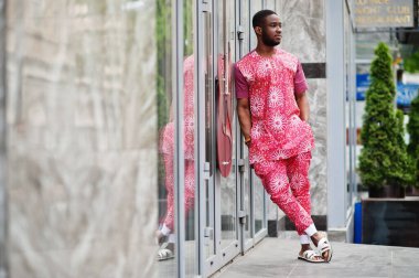 Siyah bir gencin portresi, Afrikalı geleneksel kırmızı renkli kıyafetler giyiyor..