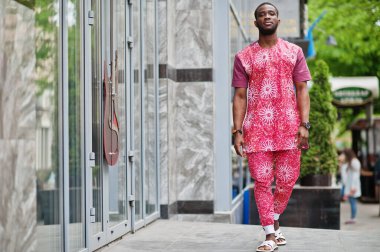 Siyah bir gencin portresi, Afrikalı geleneksel kırmızı renkli kıyafetler giyiyor..