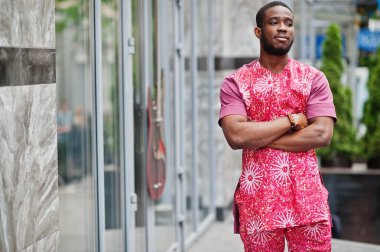 Siyah bir gencin portresi, Afrikalı geleneksel kırmızı renkli kıyafetler giyiyor..